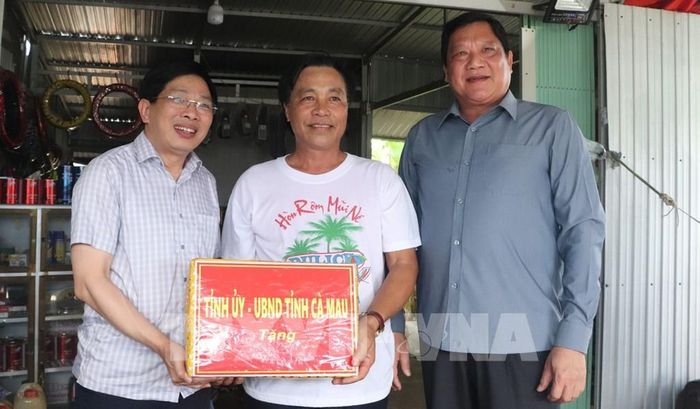 Phó Bí thư Thường trực Tỉnh ủy Cà Mau Đặng Văn Dũng tặng quà cho hộ nuôi tôm, cua sinh thái. Ảnh: Tuấn Phi - TTXVN