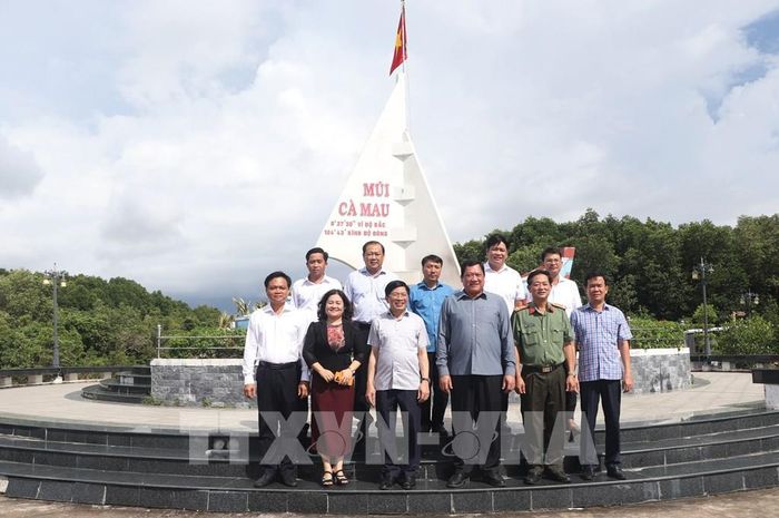 Đoàn công tác chụp ảnh lưu niệm tại biểu tượng con tàu tại xã Đất Mũi. Ảnh: Tuấn Phi - TTXVN