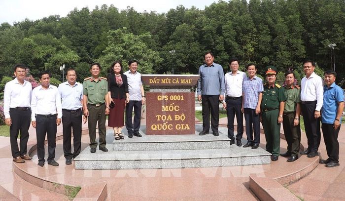 Đoàn công tác chụp ảnh lưu niệm tại cột mốc tại xã Đất Mũi. Ảnh: Tuấn Phi - TTXVN