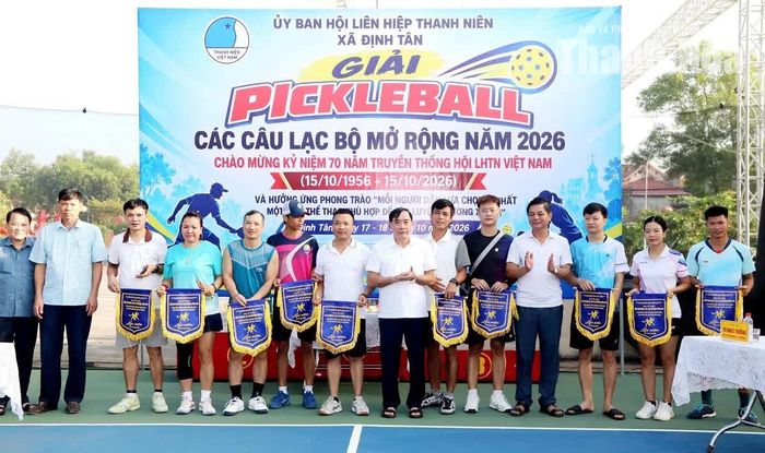 Lãnh đạo xã Định Tân và nhà tài trợ trao cờ lưu niệm cho đại diện các câu lạc bộ.