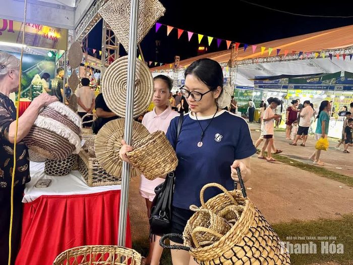 Chị Phương Trinh (phường Hạc Thành) chọn mua sản phẩm thủ công mỹ nghệ từ cói và bèo tây.