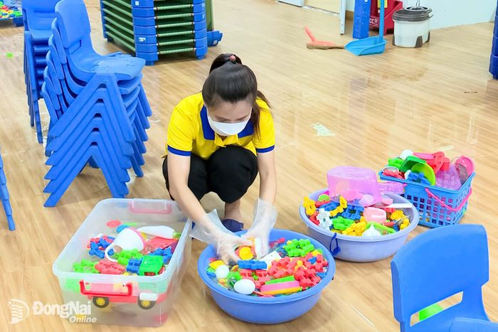 Giáo viên Trường mầm non ABi (phường Trảng Dài) vệ sinh đồ dùng, đồ chơi, góp phần phòng bệnh tay chân miệng cho trẻ.