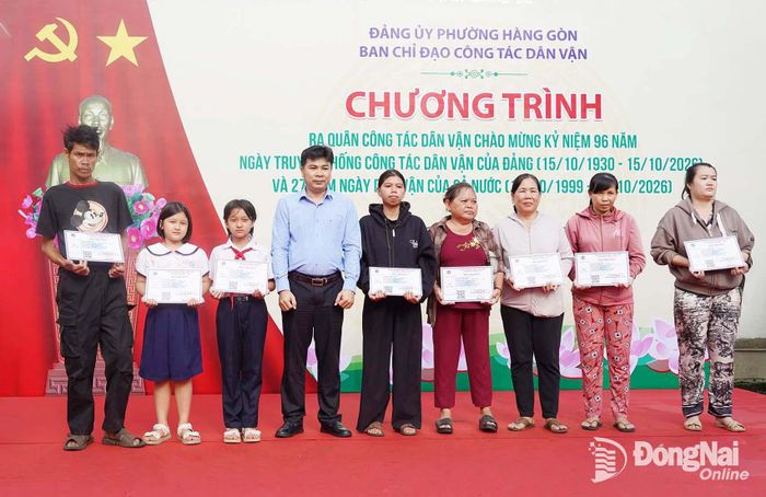 Đại diện Công ty TNHH MTV Tổng Công ty Cao su Đồng Nai trao tặng thẻ bảo hiểm y tế cho học sinh, người dân có hoàn cảnh khó khăn trên địa bàn phường Hàng Gòn. Ảnh: Thanh Tú