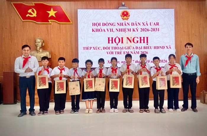  Đại diện Thường trực HĐND xã tặng quà cho trẻ em tham gia đối thoại. Ảnh: Văn Chi 