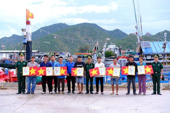 Cán bộ Bộ đội Biên phòng cùng đoàn viên, thanh niên tặng cờ Tổ quốc và ảnh Bác Hồ cho ngư dân.