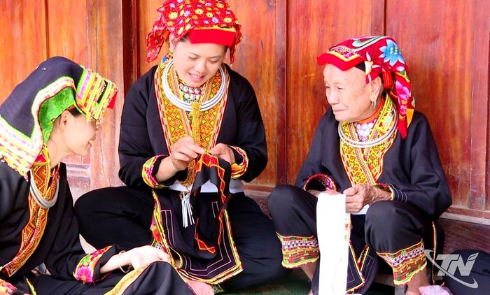 Bà Triệu Thị Thảo đang hướng dẫn nghề thêu truyền thống cho thế hệ trẻ trong xóm Na Bả.