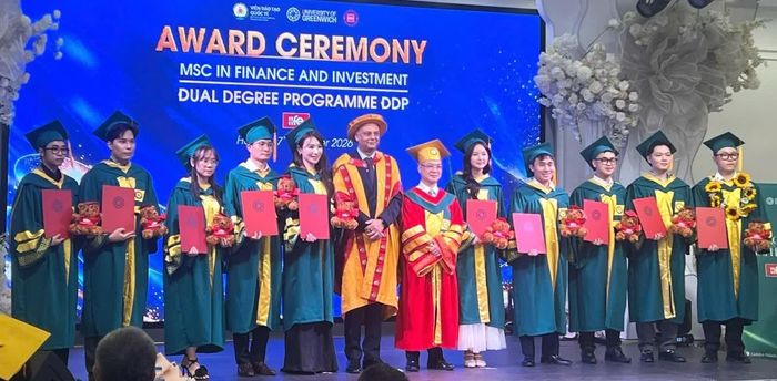 PGS.TS Nguyễn Lê Cường - Phó Giám đốc Học viện Tài chính và ông Raj Dass - Đại diện hợp tác quốc tế khu vực Đông Nam Á (Trường Đại học Greenwich) trao bằng Thạc sĩ cho các học viên. Ảnh: Đức Việt.