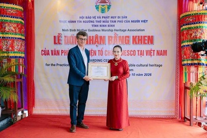 Ông Jonathan Wallace Baker, Trưởng Đại diện UNESCO tại Việt Nam trao bằng khen cho NNƯT Trần Thị Huệ