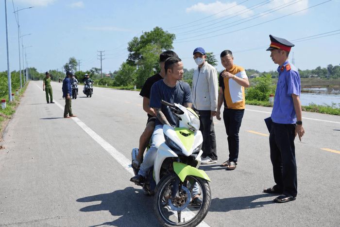 Hai đối tượng Nguyễn Công Bình (ngồi trước) và Trần Lợi (ngồi sau) thực nghiệm lại hành vi cướp giật tài sản tại hiện trường vụ án.
