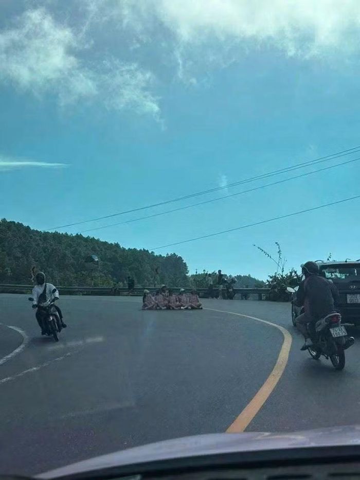 Các phương tiện ô tô, xe máy lưu thông qua vị trí nhóm phụ nữ ngồi chụp ảnh giữa lòng đường đèo Hải Vân. (ảnh CSGT)