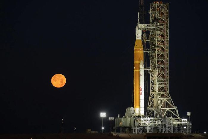 Mặt Trăng mọc phía sau tên lửa Artemis II SLS (Hệ thống Phóng Không Gian) của NASA và tàu vũ trụ Orion trên bệ phóng di động tại Tổ hợp Phóng 39B thuộc Trung tâm Vũ trụ Kennedy của NASA ở Florida (Mỹ). Nguồn: NASA