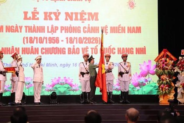 Thứ trưởng Đặng Hồng Đức gắn Huân chương Bảo vệ Tổ quốc hạng Nhì lên lá cờ truyền thống của Phòng Cảnh vệ miền Nam