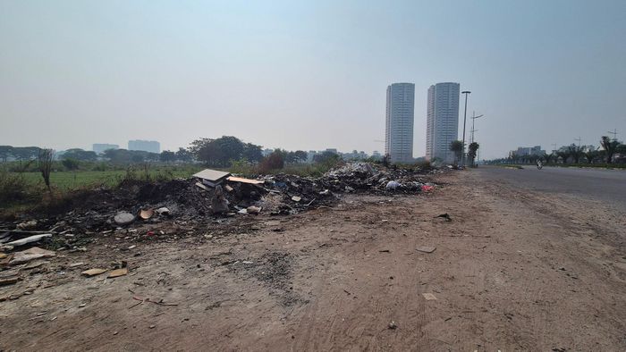 Có vị trí, rác được tập kết sát mép đường, tạo thành những mảng màu nhếch nhác trên nền cảnh quan đang được đầu tư đồng bộ của tuyến đường Vành đai 3,5. Ảnh: HL