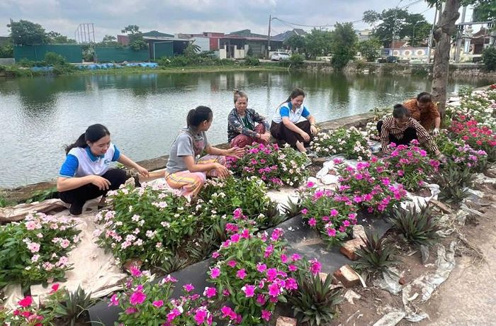 Cán bộ, hội viên Hội Liên hiệp Phụ nữ xã Phú Xuyên chăm sóc các tuyến đường hoa, tạo cảnh quan môi trường sạch, đẹp. Ảnh: PV