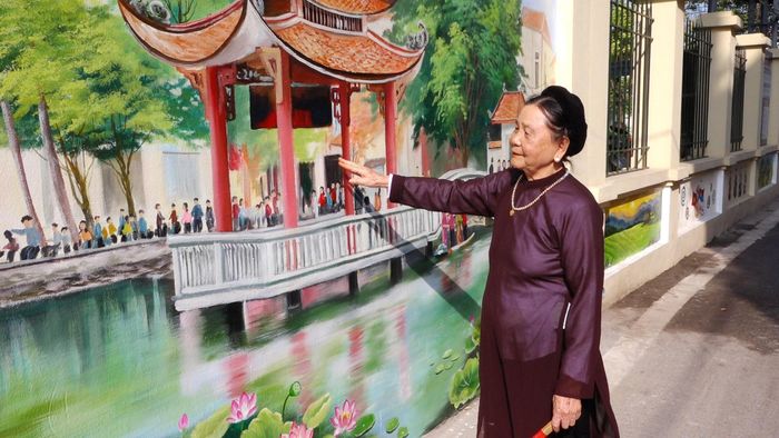 Bà Nguyễn Thị Hợi ngắm nhìn bức tranh quê hương, cảm nhận rõ những đổi thay trên mảnh đất thân thuộc. Ảnh: Đỗ Duẩn