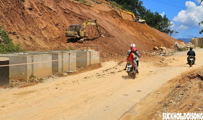 Nhiều máy móc được huy động để đào, san gạt và vận chuyển đất đá khỏi khu vực sạt lở. Ảnh: PV.