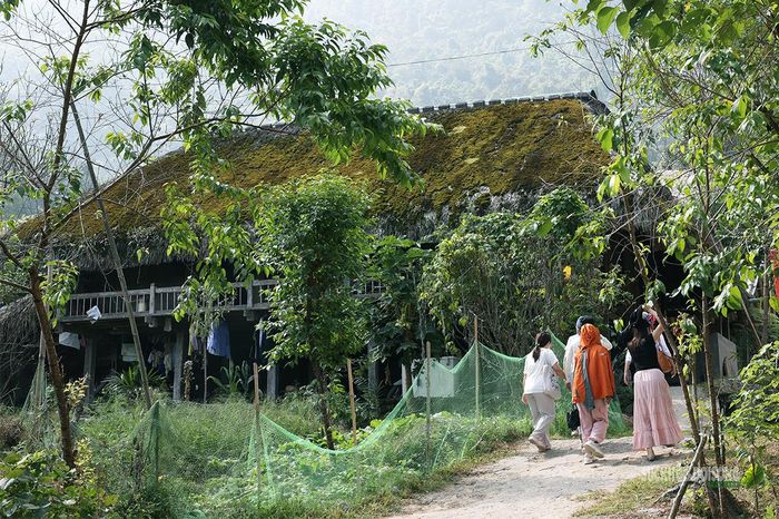 Du khách khám phá những nếp nhà sàn phủ rêu xanh tại Xà Phìn. Ảnh: Tuấn Anh