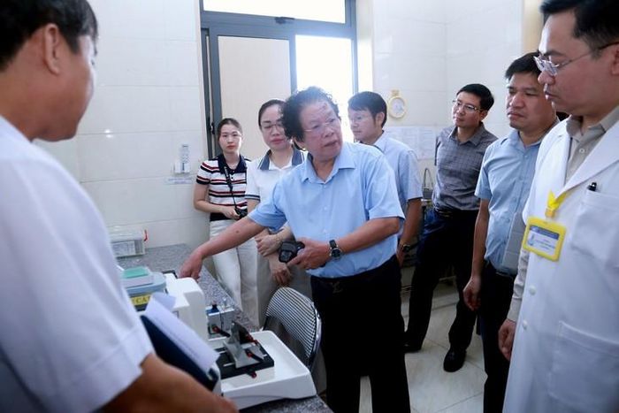 PGS.TS Lê Trung Thọ trao đổi, hướng dẫn chuyên môn về kỹ thuật giải phẫu bệnh cho đội ngũ cán bộ Bệnh viện Phổi Nghệ An. Ảnh: V. Đồng.