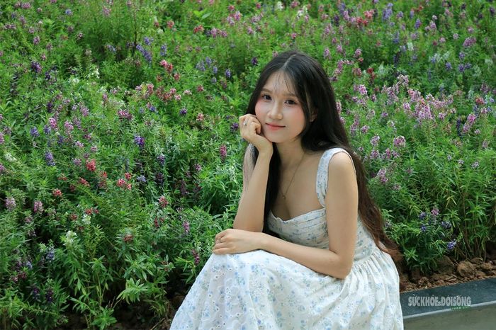Thiếu nữ duyên dáng tạo dáng bên thảm hoa violet Nhật ven hồ điều hòa. Ảnh: D. Hằng