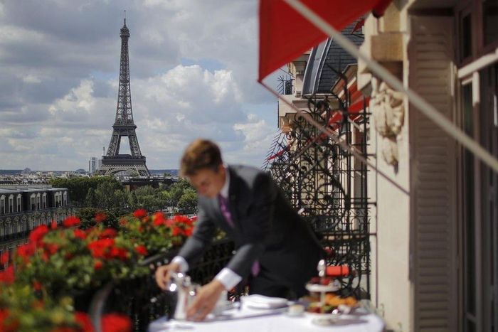  Một nhân viên chuẩn bị bữa sáng trước tháp Eiffel tại khách sạn sang trọng Le Plaza Athenee ở Paris, Pháp. Ảnh: Reuters.