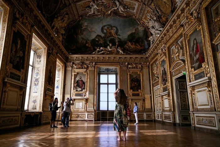  Cửa sổ của bảo tàng Louvre bị vỡ trong vụ trộm năm ngoái giờ đây lại trở thành một điểm thu hút khách du lịch. Ảnh: Lou Benoist/Reuters. 