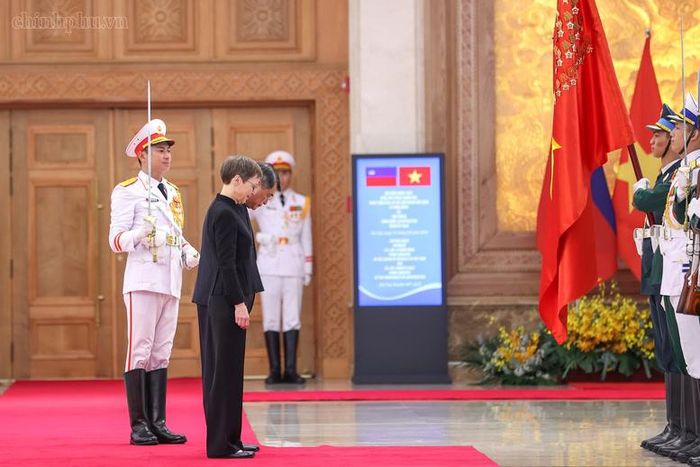 Thủ tướng Lê Minh Hưng và Thủ tướng Brigitte Haas cúi chào quân kỳ - Ảnh: chinhphu.vn/Nhật Bắc