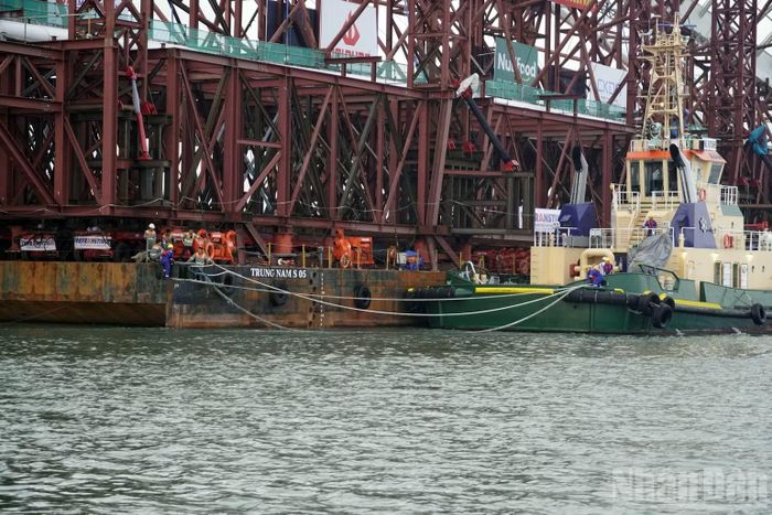 Sau khi di chuyển ra khỏi cảng và hướng ra cửa biển, sà lan dừng lại ít phút để tàu lai dắt buộc lại, kiểm tra dây giằng chắc chắn trước khi di chuyển tiếp. (Ảnh: Lê Đình Thìn)