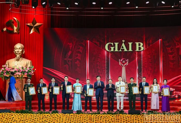 Trưởng ban Tổ chức Trung ương Nguyễn Duy Ngọc và Trưởng ban Tuyên giáo Trung ương Trịnh Văn Quyết trao giải B cho các tác giả, nhóm tác giả. (Ảnh: DUY LINH)