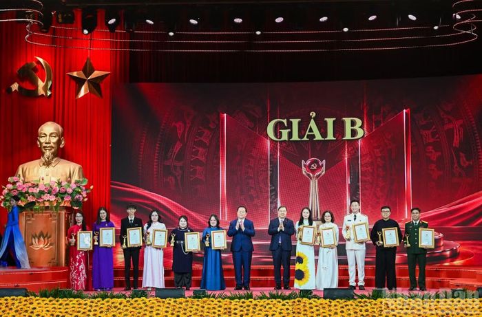 Phó Thủ tướng Thường trực Chính phủ Phạm Gia Túc và Chủ nhiệm Tổng cục Chính trị Quân đội nhân dân Việt Nam Nguyễn Trọng Nghĩa trao giải B cho các tác giả, nhóm tác giả. (Ảnh: DUY LINH)