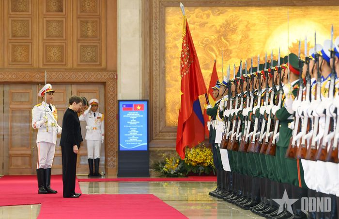  Thủ tướng Lê Minh Hưng và Thủ tướng Brigitte Haas cúi chào quân kỳ. Ảnh: PHƯƠNG LINH