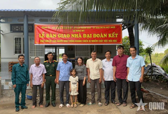 Lãnh đạo xã Hưng Mỹ, tỉnh Cà Mau chụp ảnh cùng gia đình ông Trần Quốc Khánh ở ấp Rạch Dược- hộ được trao tặng nhà Đại đoàn kết.