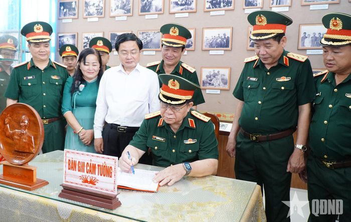 Đại tướng Nguyễn Trọng Nghĩa ghi sổ cảm tưởng tại Nhà truyền thống Cơ quan Chính trị Quân khu 8.