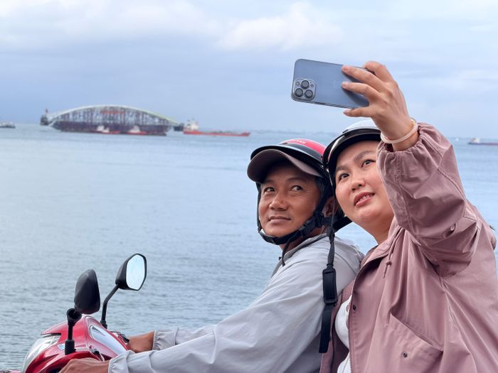  Hai người dân dừng xe bên đường ven biển Bãi Dâu, phường Vũng Tàu, chụp ảnh lưu niệm. Ảnh: HOÀNG HÙNG 
