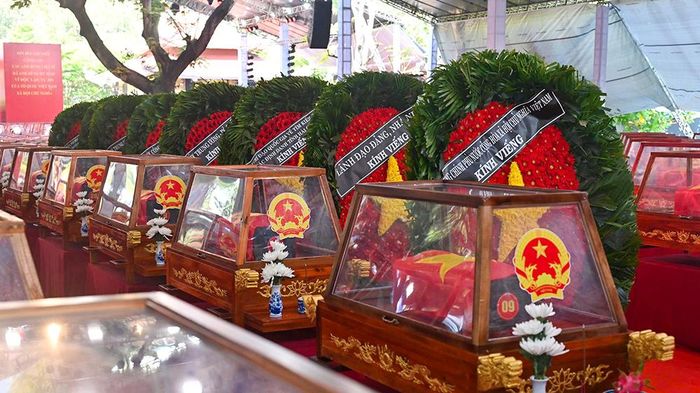 Các hài cốt liệt sĩ trước giờ an táng được trang trọng đặt trong lòng kính, phủ cờ Tổ quốc