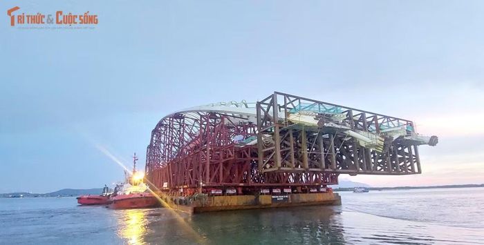 Toàn bộ tổ hợp được đặt trên sà lan chuyên dụng dài 109 m, rộng 37 m, tải trọng lên đến 14.000 tấn. Khoảng 50 trụ kê bằng thép và bê tông được bố trí để phân bổ tải trọng, tăng độ ổn định trong quá trình lai dắt.