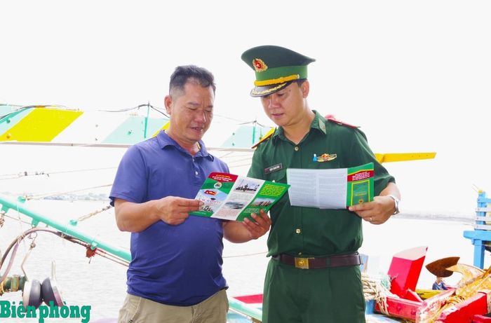 Cán bộ Đồn Biên phòng Phước Tỉnh phát tờ rơi tuyên truyền, vận động ngư dân chấp hành các quy định trong hoạt động khai thác thủy sản, tích cực tham gia tố giác tội phạm. Ảnh: Lê Khoa
