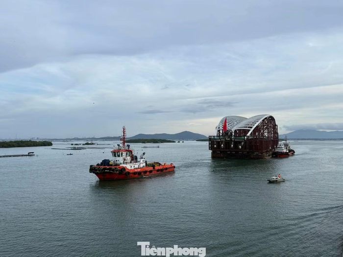 Tàu kéo và các phương tiện hỗ trợ phối hợp điều hướng sà lan chở nhịp chính cầu đi bộ qua sông Sài Gòn.