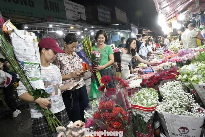 Những bó hoa đủ màu sắc được bày kín các sạp, người mua tranh thủ lựa chọn, trong khi tiểu thương liên tục sắp xếp, vận chuyển hàng.