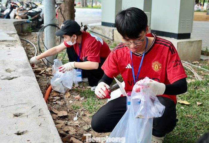 Các thành viên hỗ trợ nhau trong quá trình nhặt rác, thể hiện tinh thần đồng đội và sự phối hợp để hoàn thành phần thi.