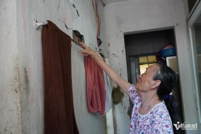 Bà Nguyễn Thị Châu chỉ vào vết nứt kéo dài tại khu vực nhà tắm, nhà vệ sinh.