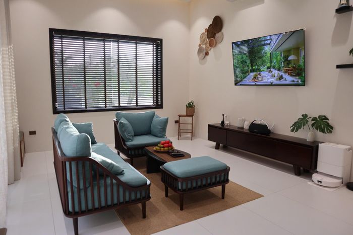 Khu vực phòng khách thoáng sáng nhờ hệ cửa cỡ lớn, nổi bật với bộ ghế màu xanh