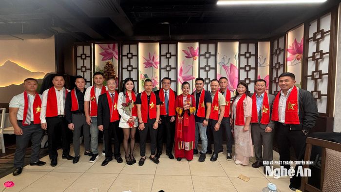 Đoàn công tác tỉnh Nghệ An tặng khăn in cờ Tổ quốc tặng kiều bào tại chương trình gặp mặt. Ảnh: Thanh Huyền