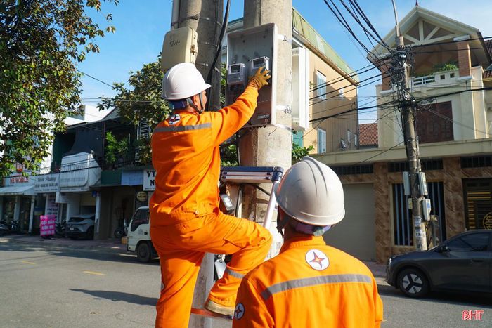 Nhân viên Điện lực lắp đặt hệ thống đo đếm điện hai chiều phục vụ mua bán điện dư từ hệ thống điện mặt trời mái nhà.