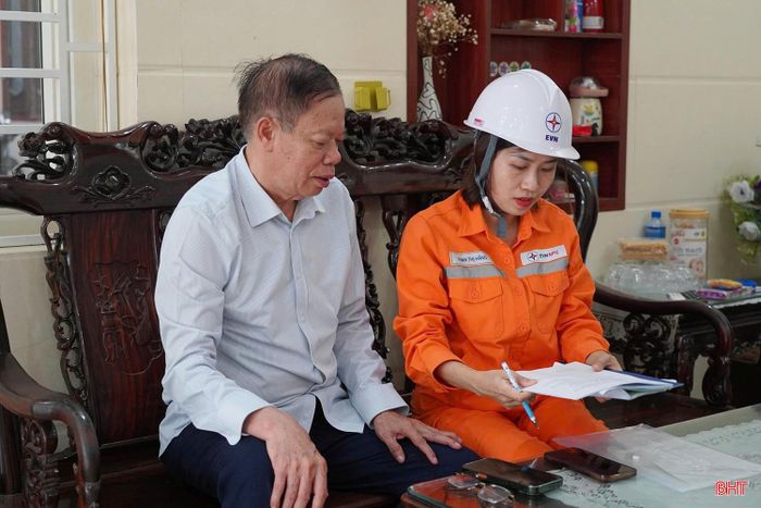 Cán bộ Điện lực Thành Sen hướng dẫn ông Thái Tiến Dũng hoàn thiện hồ sơ bán điện dư từ hệ thống điện mặt trời mái nhà.