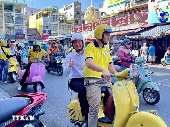 Du khách hào hứng trải nghiệm du lịch Thành phố Hồ Chí Minh bằng xe Vespa. (Ảnh minh hoạ: Mỹ Phương/TTXVN)