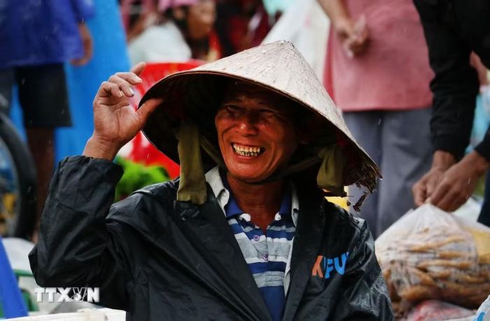 Nhiều hôm trời mưa, những người bán hàng vẫn tươi cười, kiên nhẫn ngồi bên những mẹt hàng giản dị, chờ khách ghé mua. (Ảnh: Duy Khương/TTXVN)