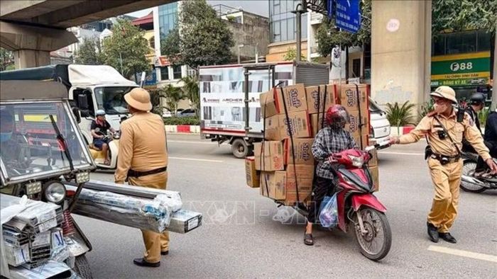 Lực lượng Cảnh sát giao thông Hà Nội kiểm tra xe máy chở hàng hóa cồng kềnh trên đường Quang Trung - Quốc lộ 6. Ảnh minh họa: Trung Nguyên/TTXVN
