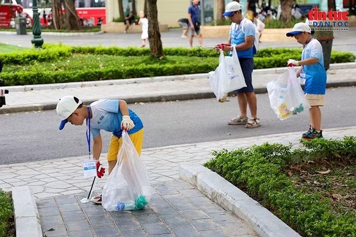 Các bạn nhỏ cùng người lớn tham gia nhặt rác, lan tỏa ý thức giữ gìn môi trường từ những hành động thiết thực.