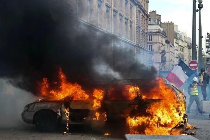Một chiếc xe bốc cháy trong cuộc biểu tình ở Paris hôm thứ Bảy. Ảnh: Xinhua.