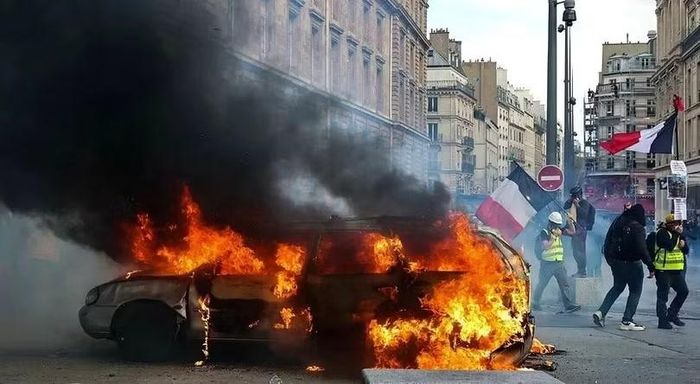 Người biểu tình đốt xe trên đường phố Paris. Ảnh: Xinhua.
